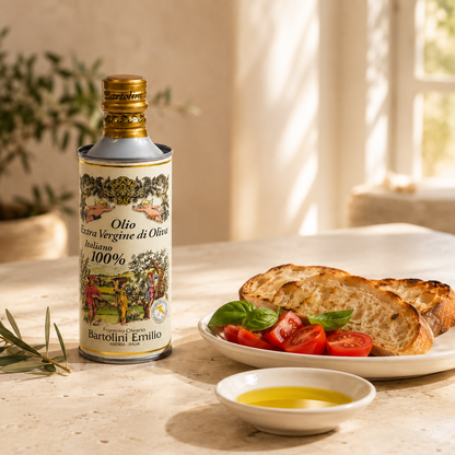 Emilio Bartolini Olivenöl Extra Vergine mit Brot, Tomaten und Basilikum auf mediterran gedecktem Tisch